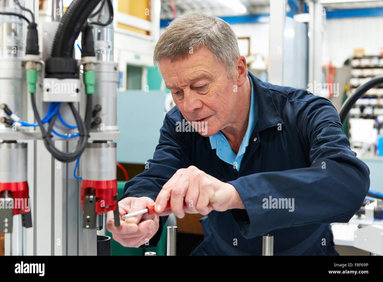 Ingénieur travaillant sur la machine en usine Banque D'Images