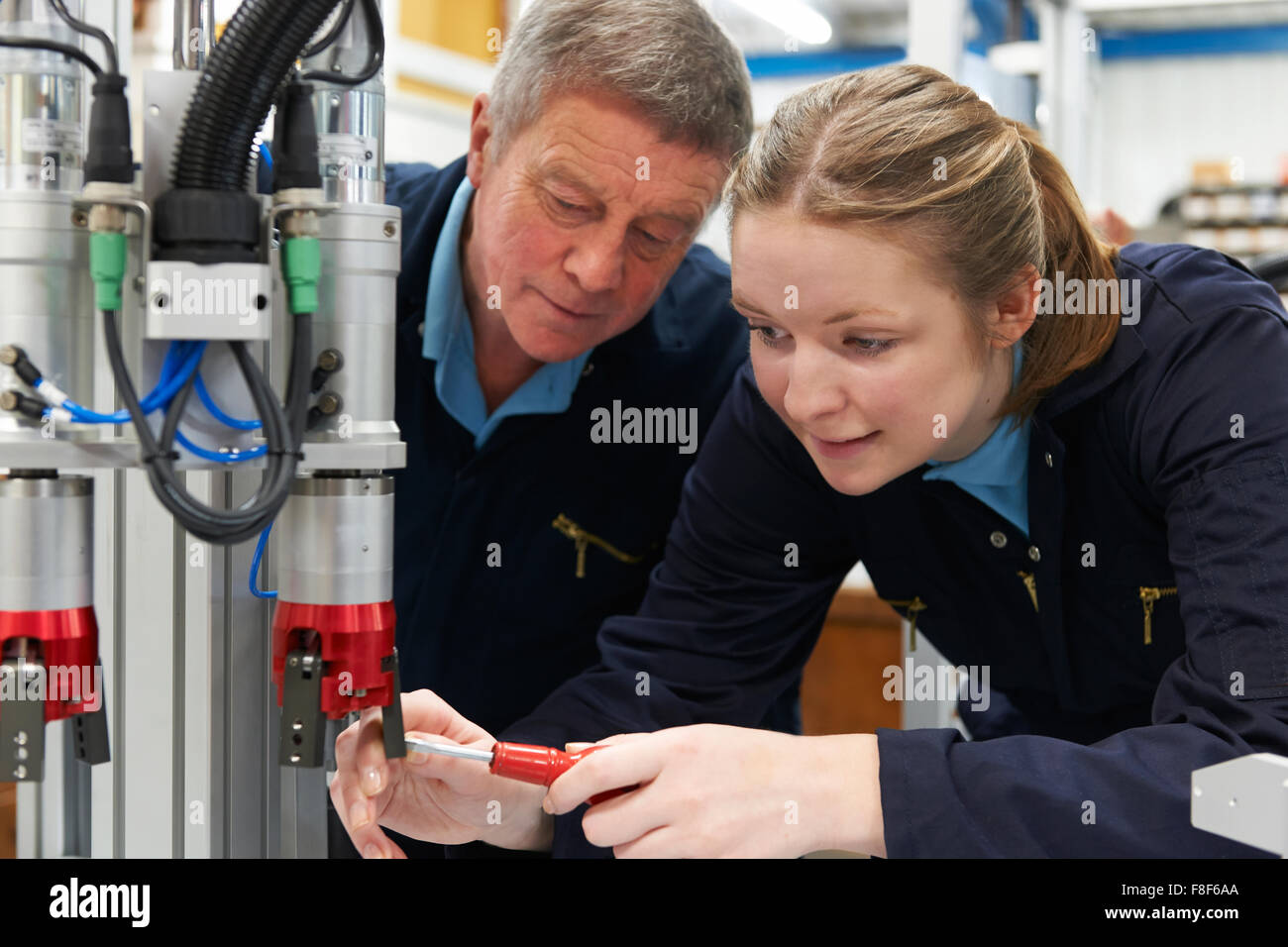 Apprenti ingénieur et de travailler sur la machine en usine Banque D'Images
