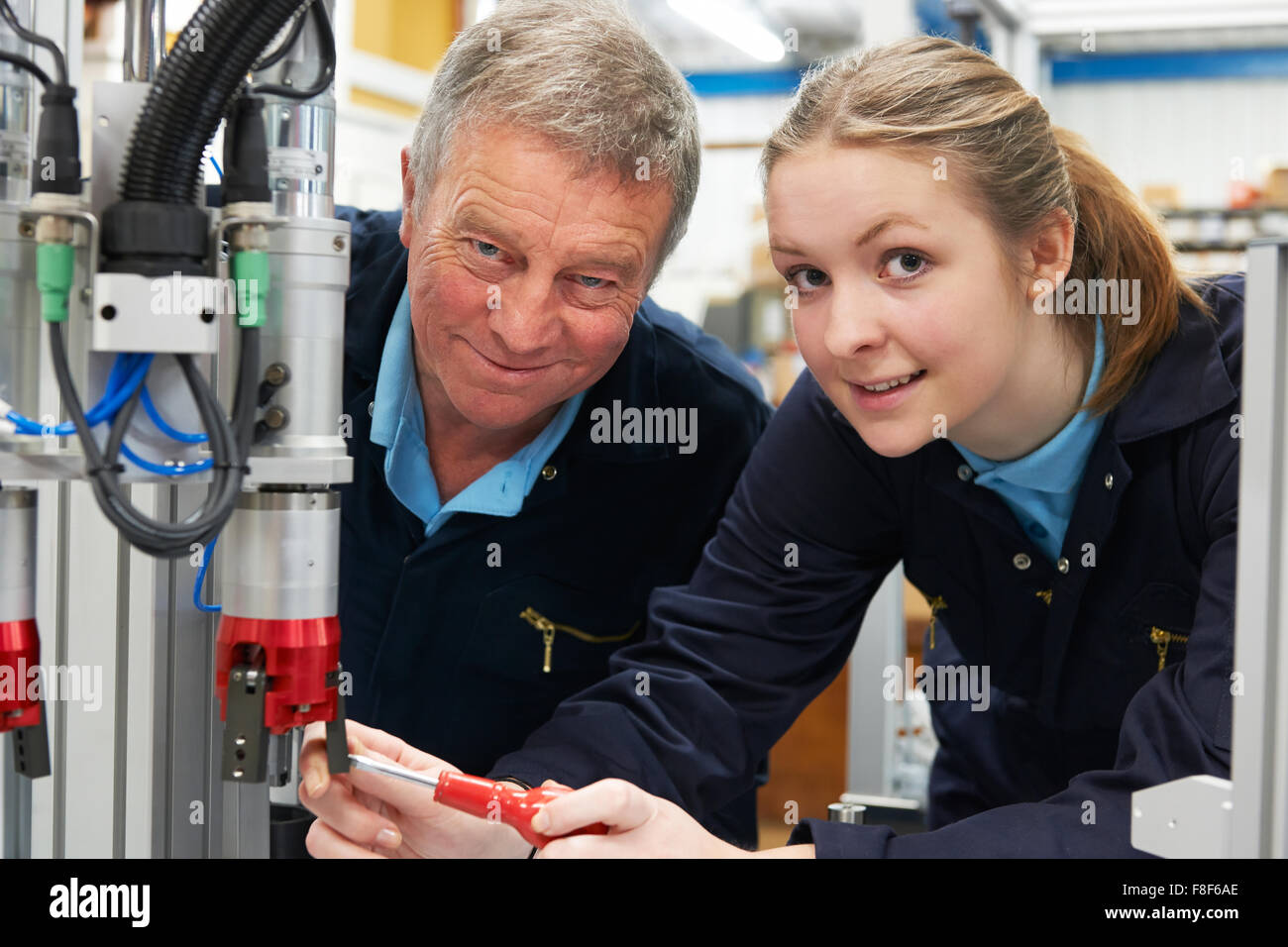 Apprenti ingénieur et de travailler sur la machine en usine Banque D'Images