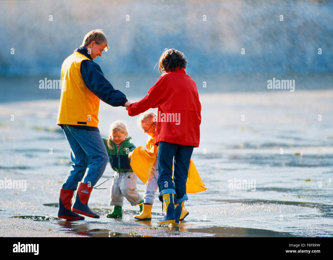Familie mit 2 Kindern dans Regenklamotten bunten beim spielen und numérique Promenade, KO-Dia Banque D'Images