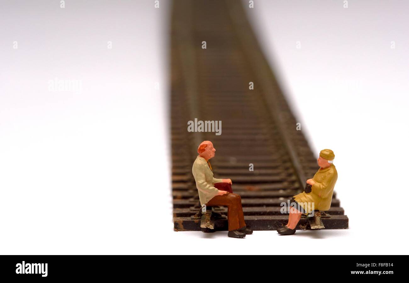 2 pensionnés miniature assis sur modèle réduit de chemin de fer. Concept en voie de retraite Banque D'Images