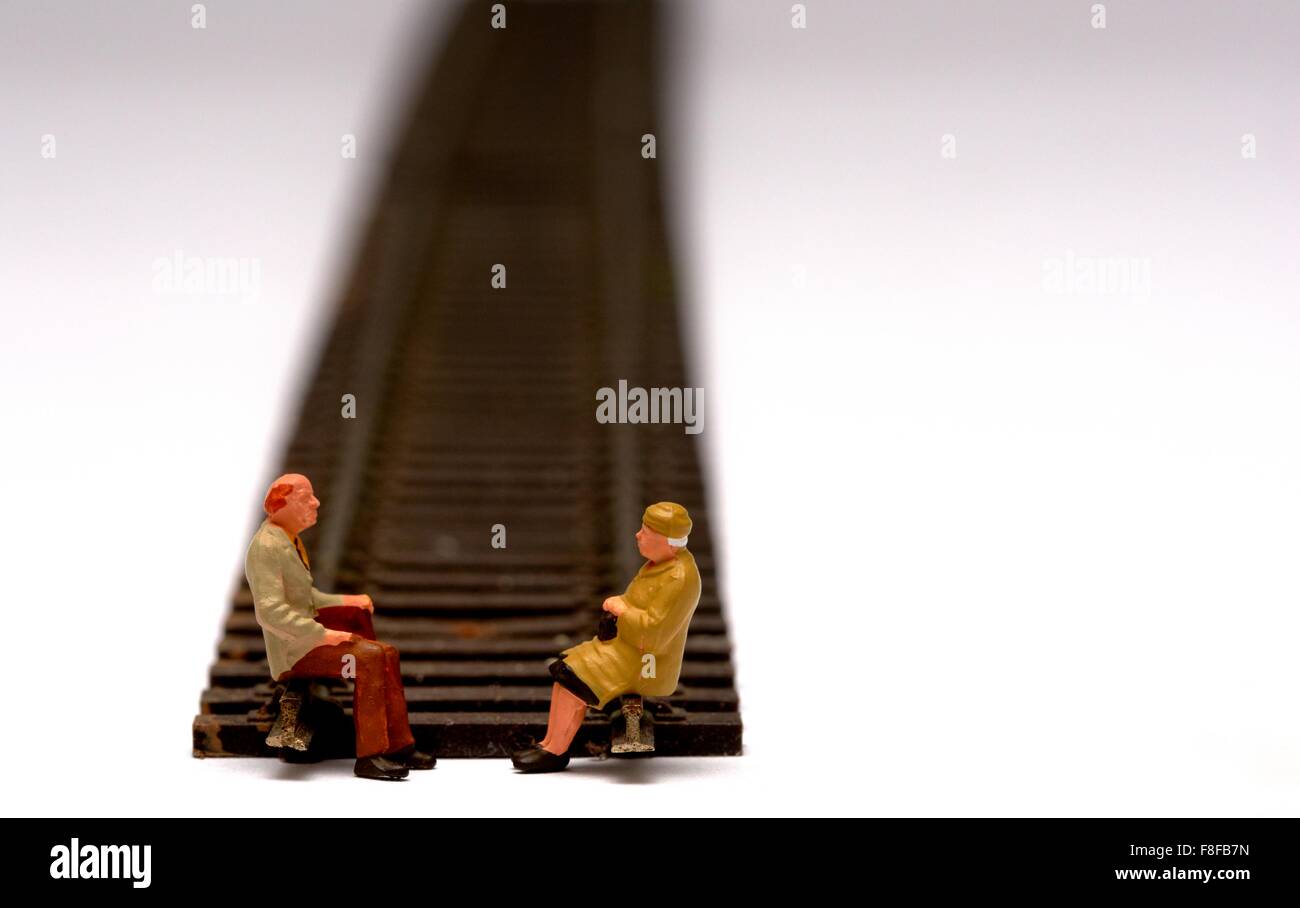 2 pensionnés miniature assis sur modèle réduit de chemin de fer. Concept en voie de retraite Banque D'Images