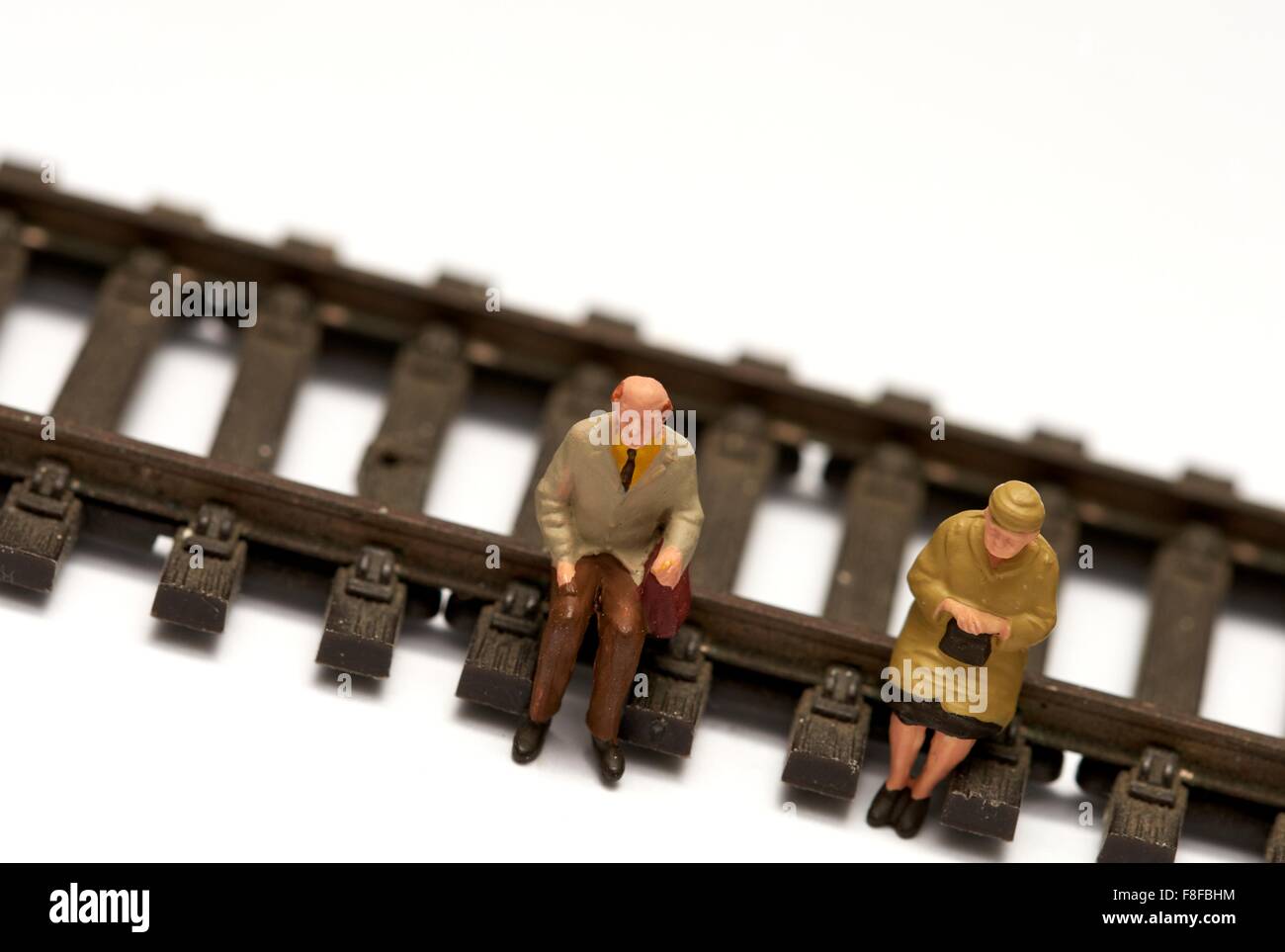 2 pensionnés miniature assis sur modèle réduit de chemin de fer. Concept en voie de retraite Banque D'Images