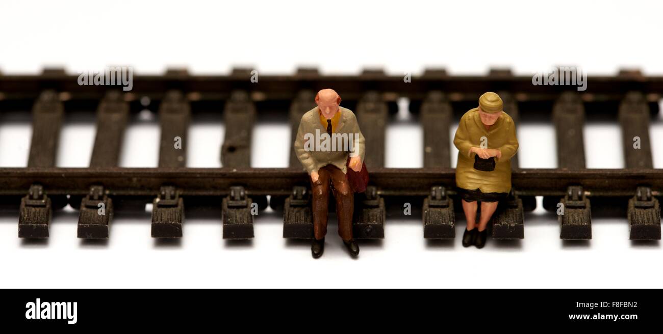 2 pensionnés miniature assis sur modèle réduit de chemin de fer. Concept en voie de retraite Banque D'Images