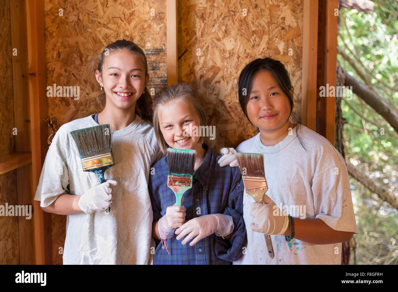 Smiling girls painting house Banque D'Images
