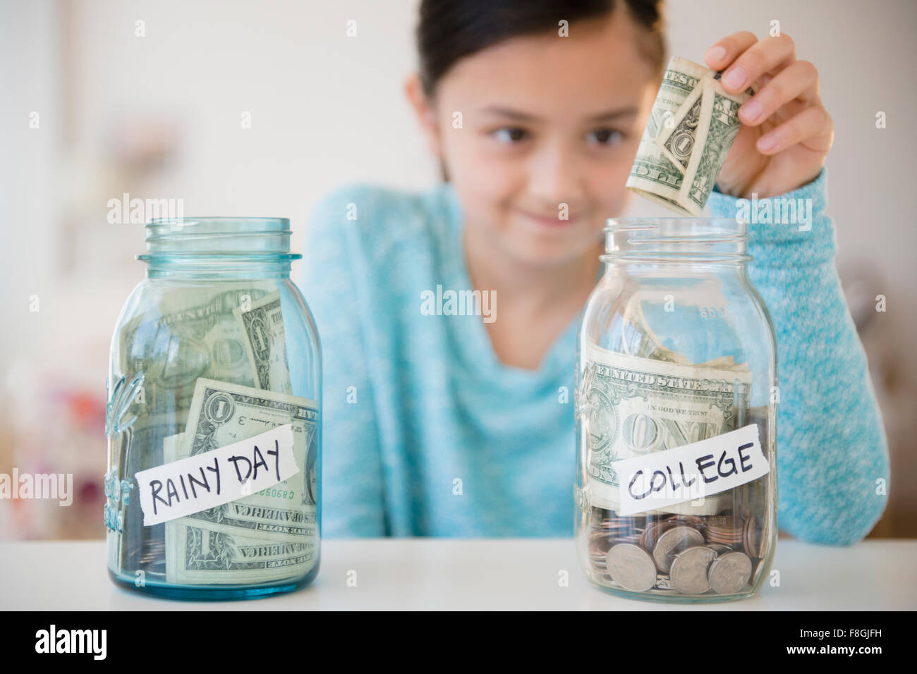 Fille d'économiser de l'argent dans le fonds du collège Banque D'Images
