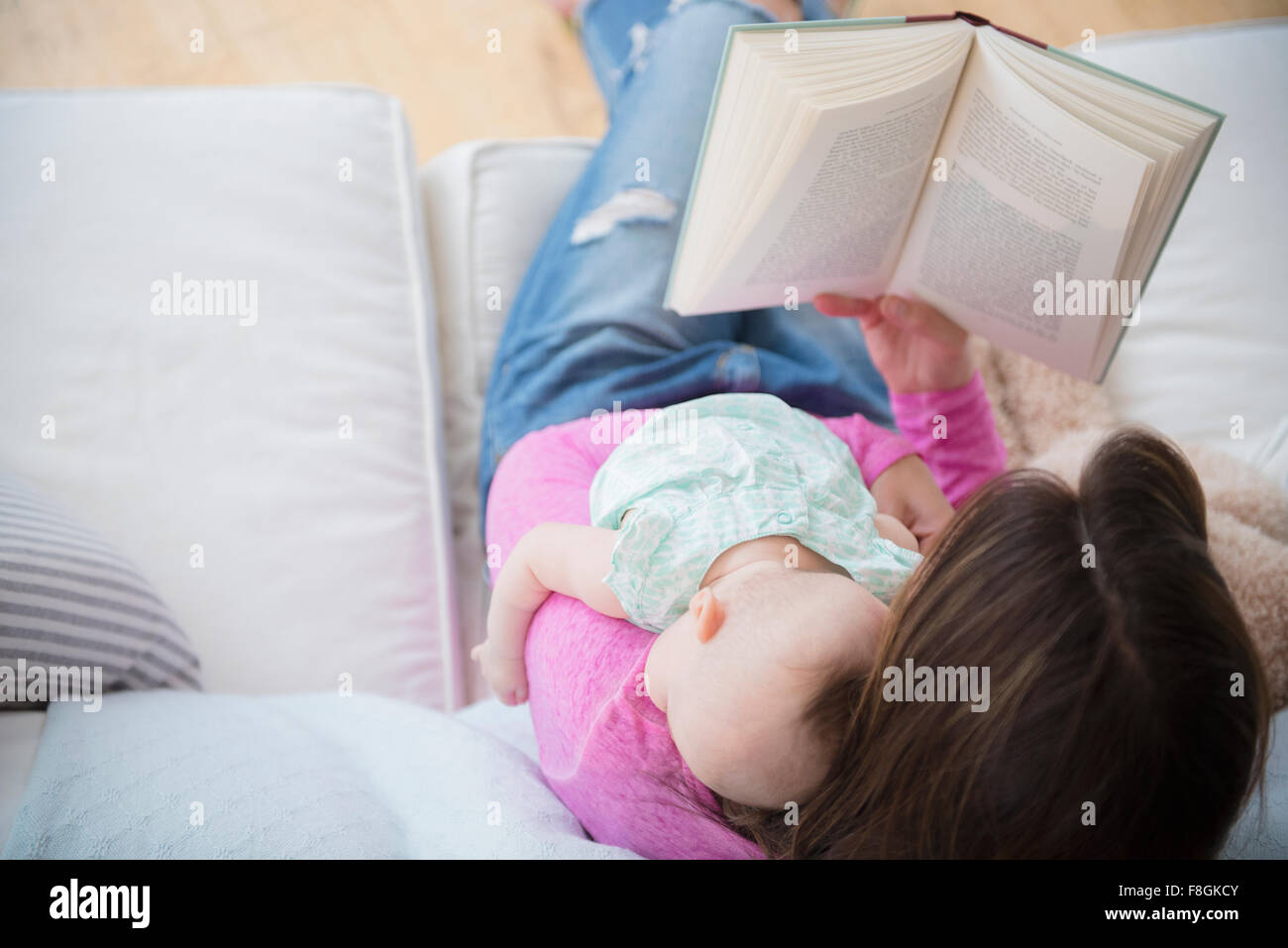 Livre et Lecture mère holding baby daughter Banque D'Images