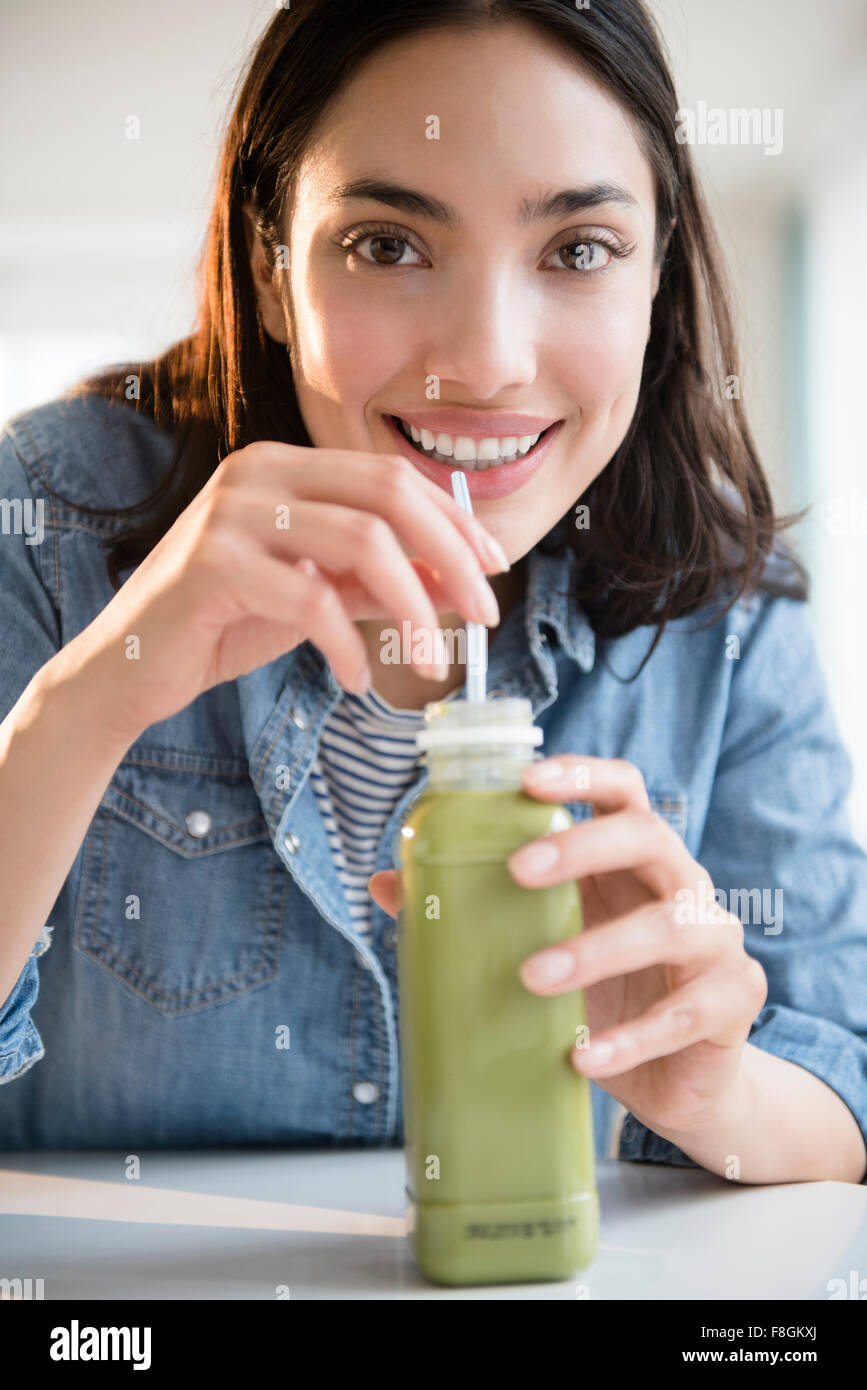 Hispanic woman drinking jus vert Banque D'Images
