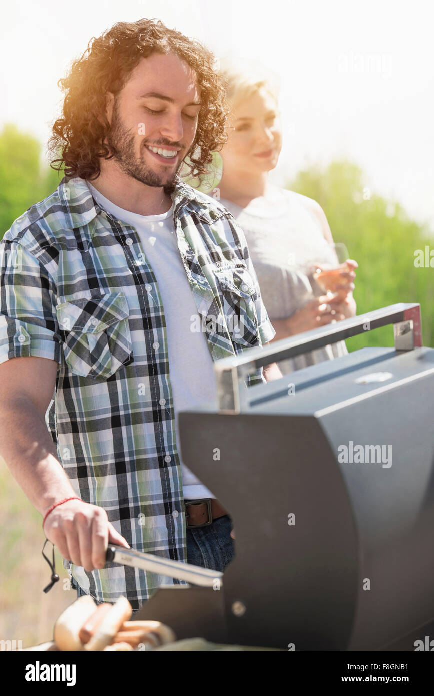 Caucasian man grilling at barbecue Banque D'Images