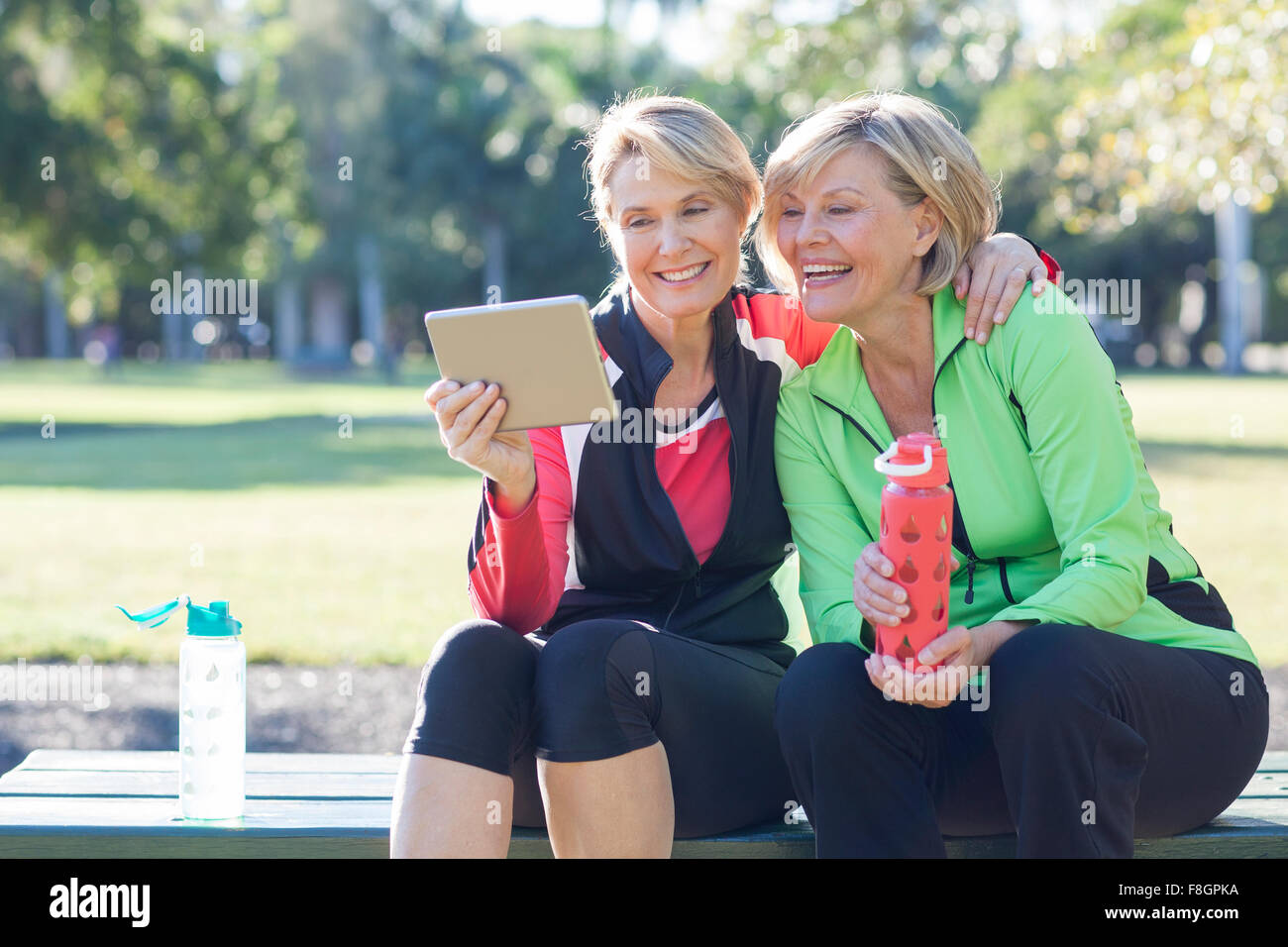 Caucasian women using digital tablet in park Banque D'Images