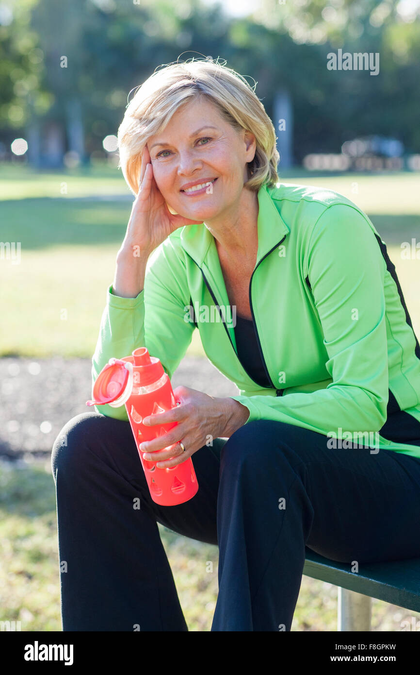 Caucasian woman drinking water bottle in park Banque D'Images