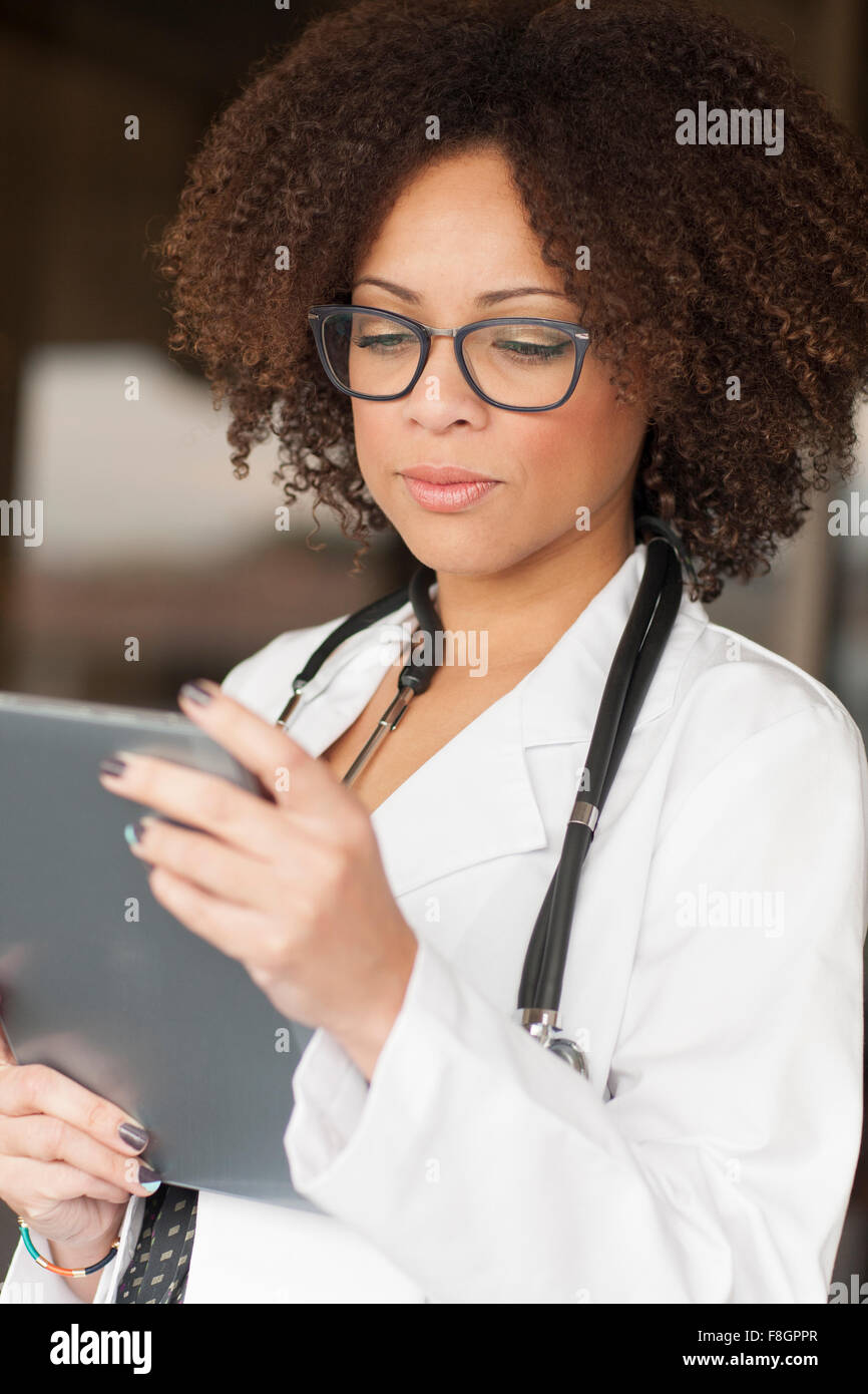Mixed Race doctor using digital tablet Banque D'Images