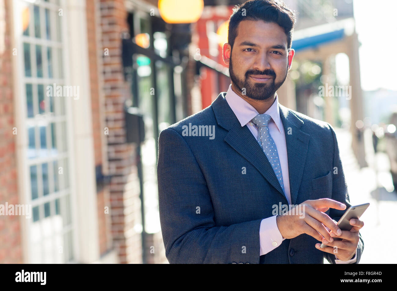 Indian businessman using cell phone in city Banque D'Images