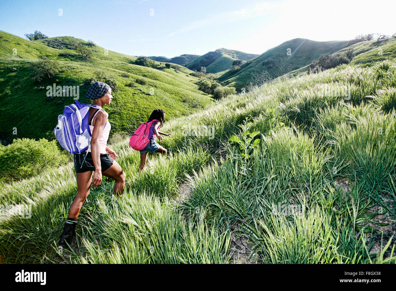 Black mother and daughter walking on rural hillside Banque D'Images