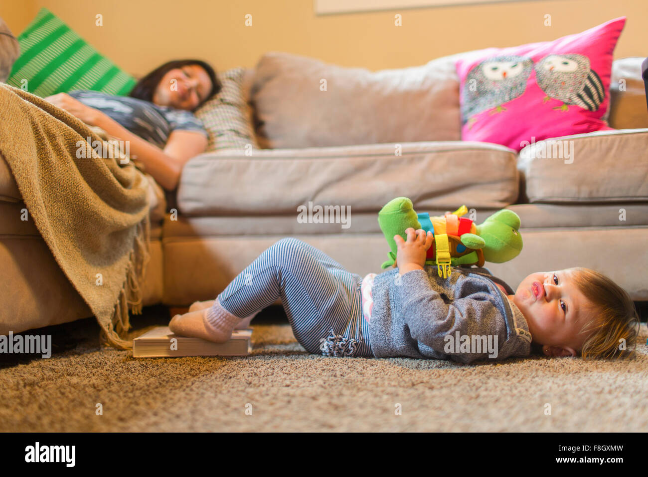 Mère et fille bébé relaxing in living room Banque D'Images