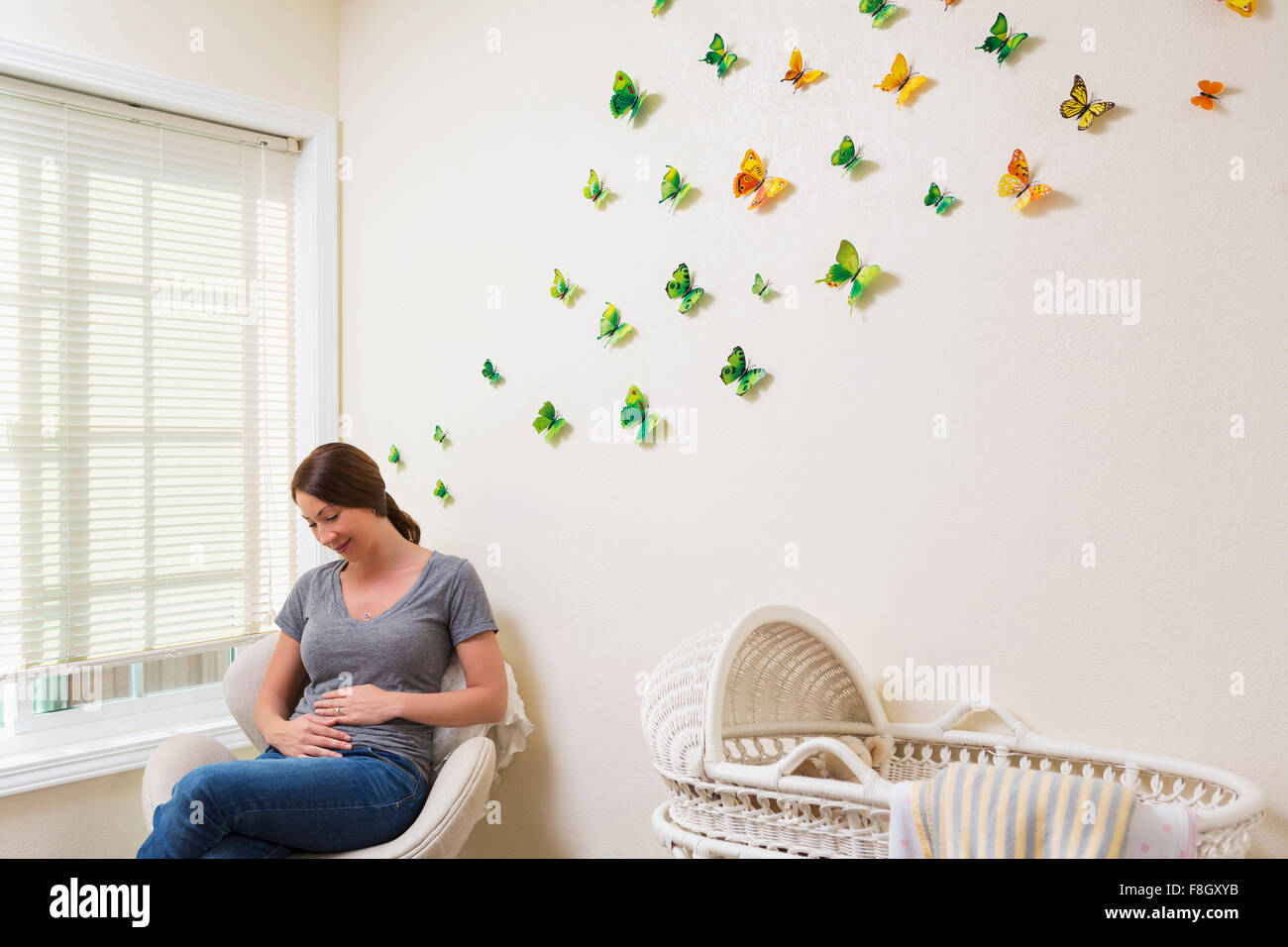 Young pregnant woman sitting in nursery Banque D'Images