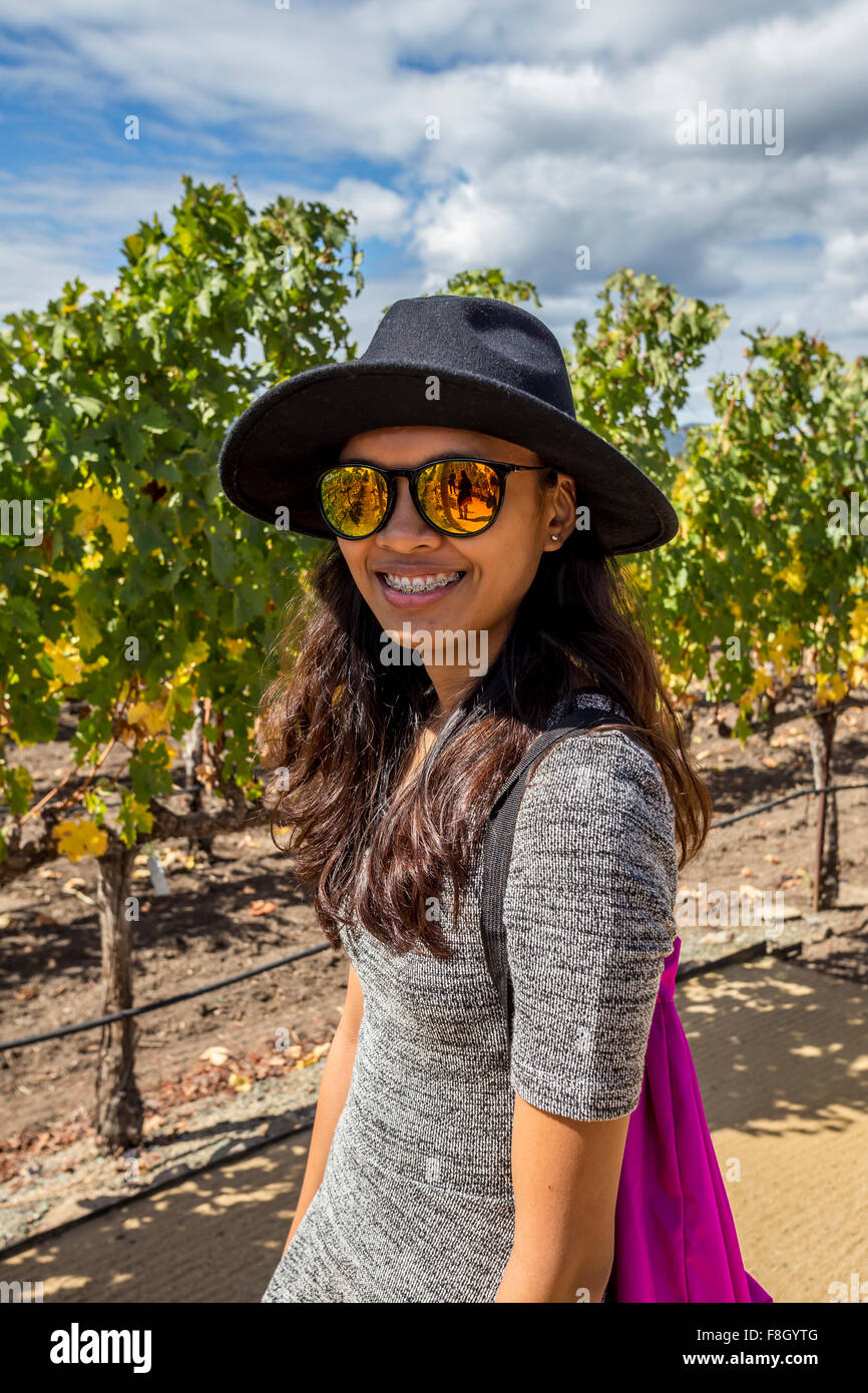 Young adult woman, touristiques, raisin, raisin vigne vignes, vignobles, Darioush Winery, Silverado Trail, Napa Valley, Comté de Napa, Californie Banque D'Images