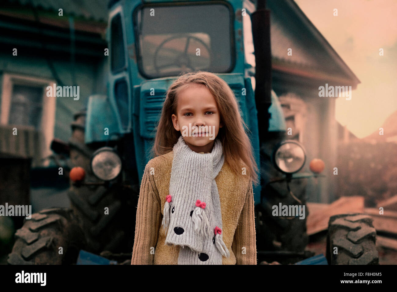 Caucasian Girl standing près de tracteur Banque D'Images