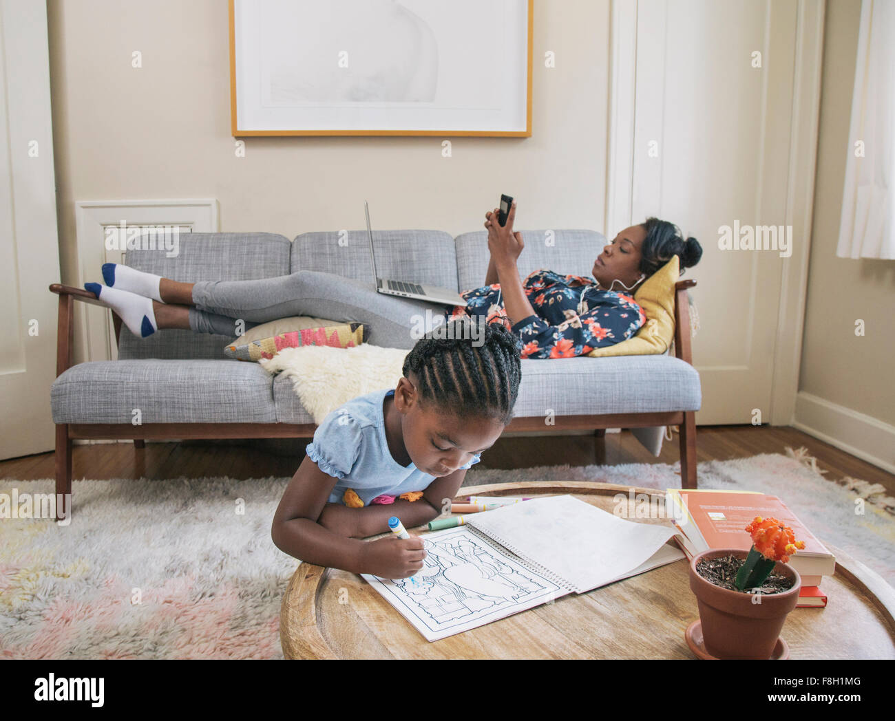 African American mother and daughter relaxing in living room Banque D'Images