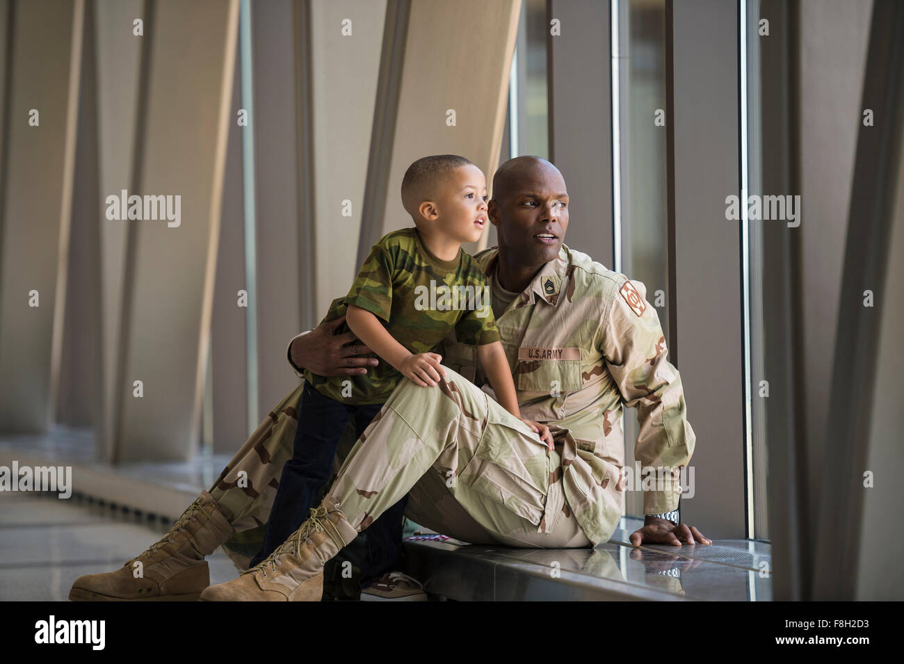 Soldat afro-américain et son fils à la fenêtre de l'aéroport hors Banque D'Images