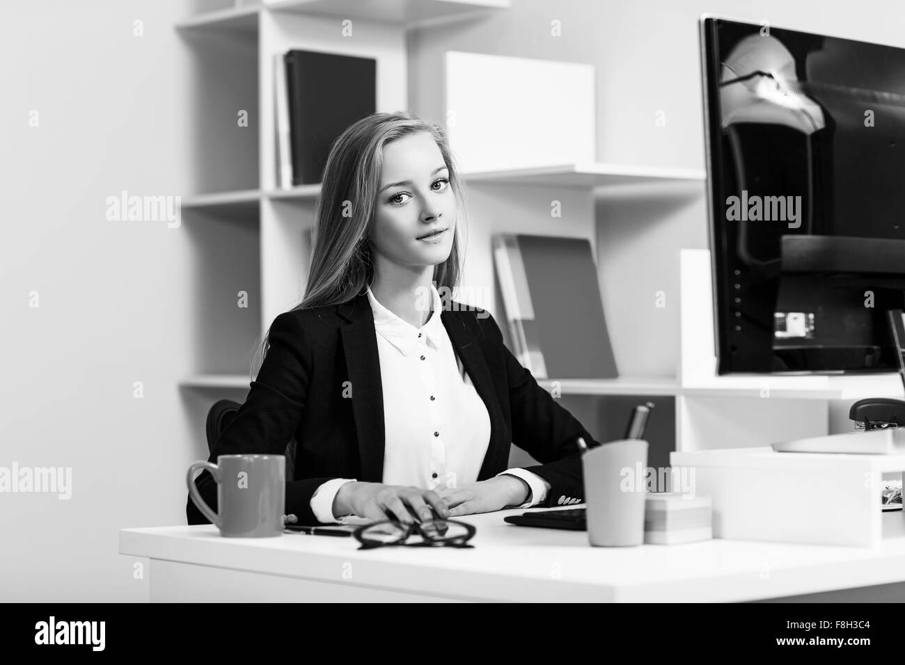 Femme assise au bureau avec ordinateur Banque D'Images