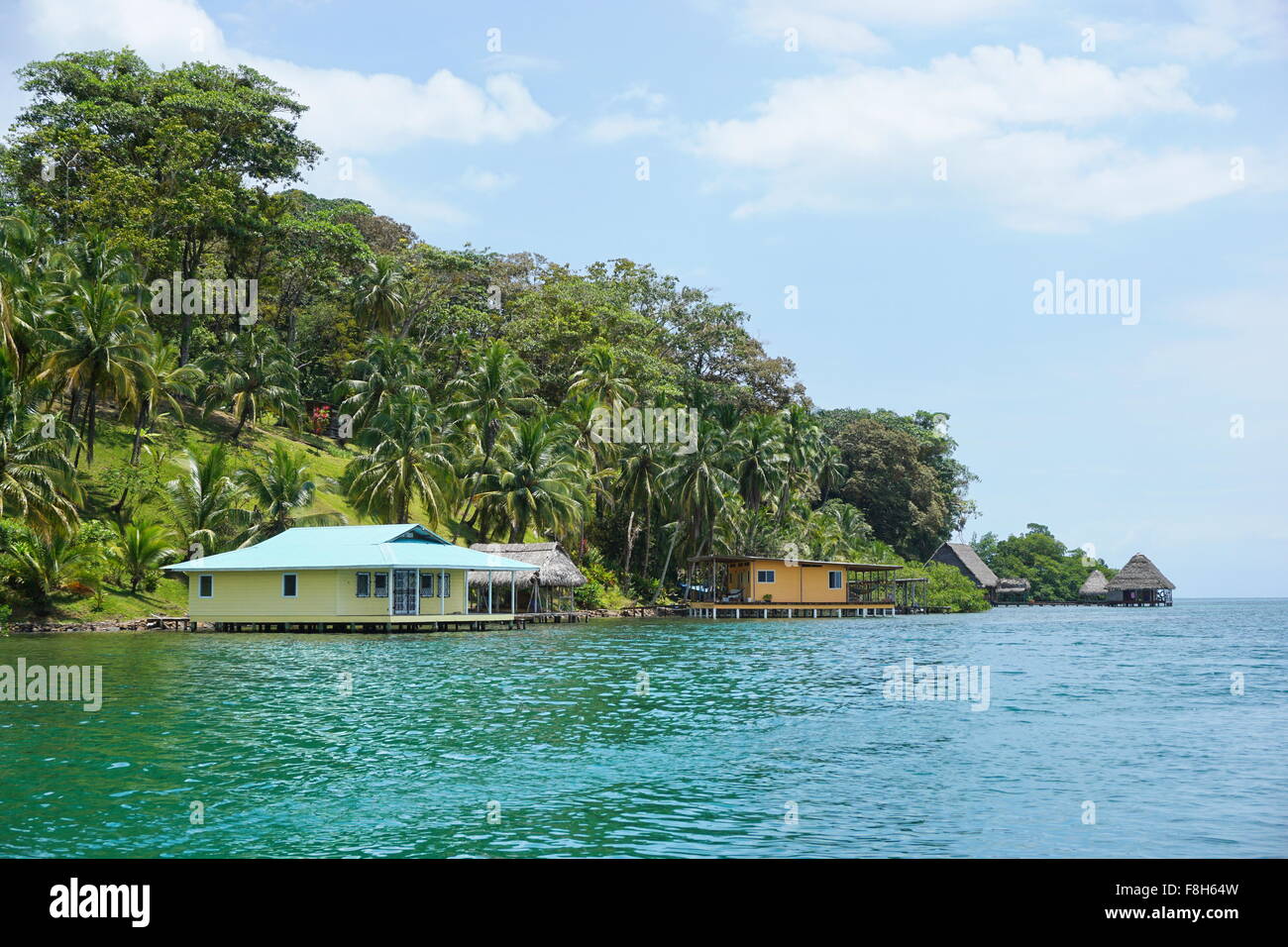 Une végétation luxuriante, sur la côte tropical avec des maisons et des huttes sur l'eau, vue de la mer, des Caraïbes, Panama, Amérique Centrale Banque D'Images