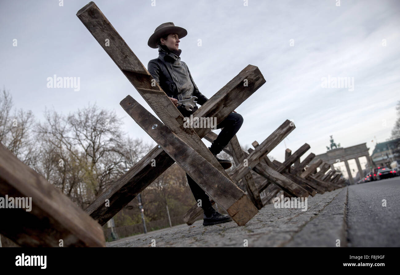 Berlin, Allemagne. Dec 10, 2015. Dafne artiste B est à son installation en bois composé de 50 obstacles antichars positionnés sur une bande d'une rue du centre de Berlin, Allemagne, 10 décembre 2015. L'artiste a l'intention de traiter les blocs mentale à travers son art installation 'X Die Sperre im Kopf X' (lit. X La barrière dans la tête X) sur la Journée des droits de l'homme. Photo : MICHAEL KAPPELER/dpa/Alamy Live News Banque D'Images