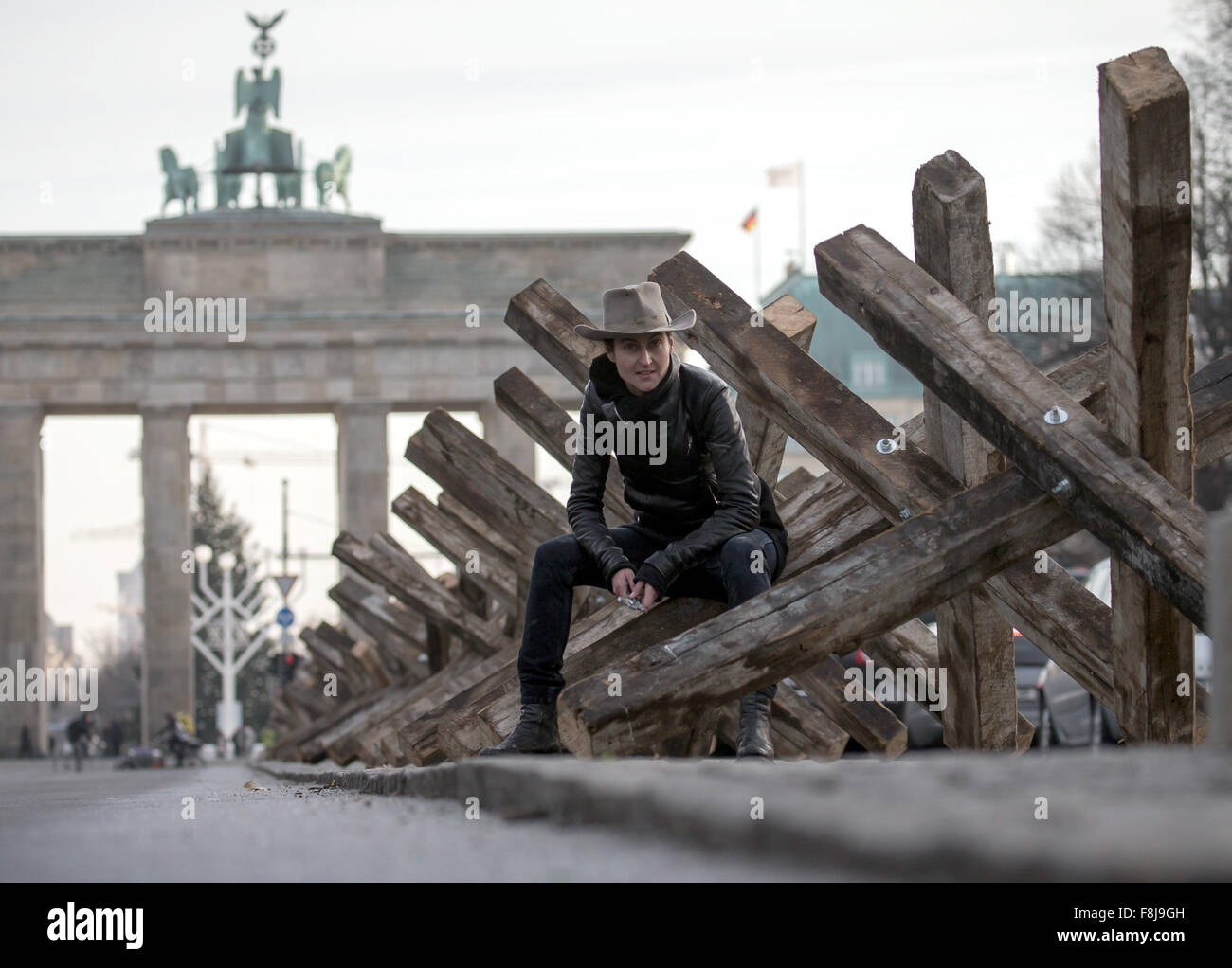 Berlin, Allemagne. Dec 10, 2015. Dafne artiste B est à son installation en bois composé de 50 obstacles antichars positionnés sur un bourrelet central d'une rue, avec la porte de Brandebourg, représenté à l'arrière-plan, à Berlin, Allemagne, 10 décembre 2015. L'artiste a l'intention de traiter les blocs mentale à travers son art installation 'X Die Sperre im Kopf X' (lit. X La barrière dans la tête X) sur la Journée des droits de l'homme. Photo : MICHAEL KAPPELER/dpa/Alamy Live News Banque D'Images