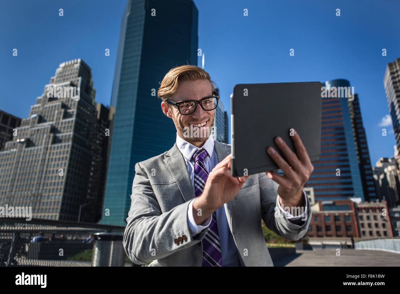 Young businessman using digital tablet en face de l'écran tactile, New York, USA Banque D'Images