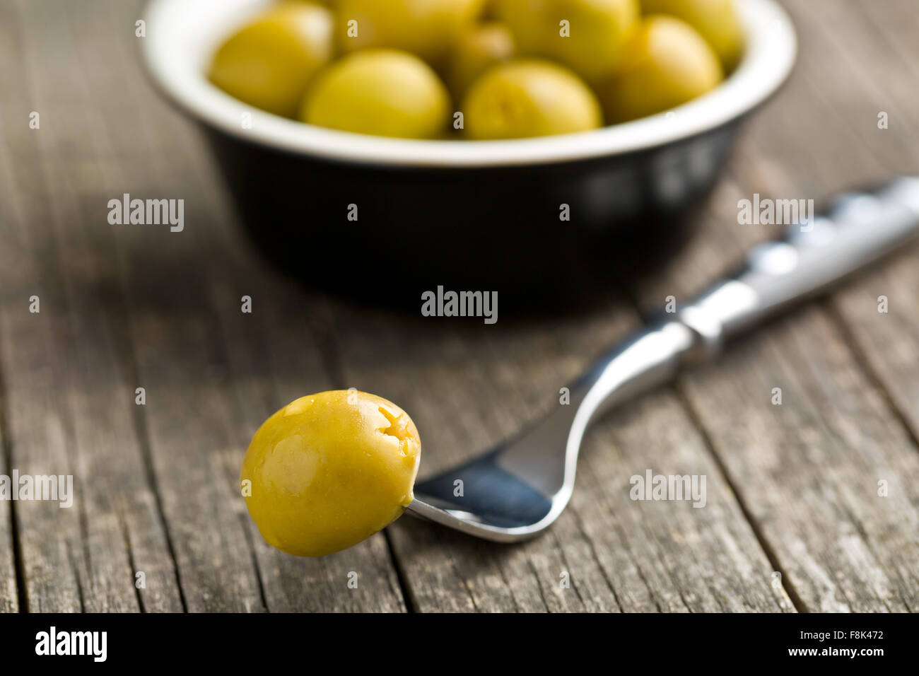 Olives vertes dénoyautées sur table en bois Banque D'Images