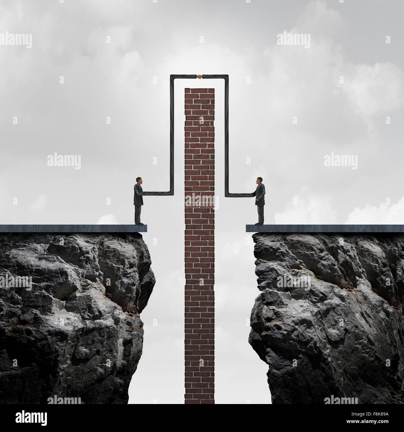 Faire un deal à surmonter les obstacles à un accord comme un concept d'affaires de partenariat flexible solide succès comme deux personnes isolées sur des falaises s'étendant leurs bras pour contourner un mur de brique pour une poignée de connexion. Banque D'Images