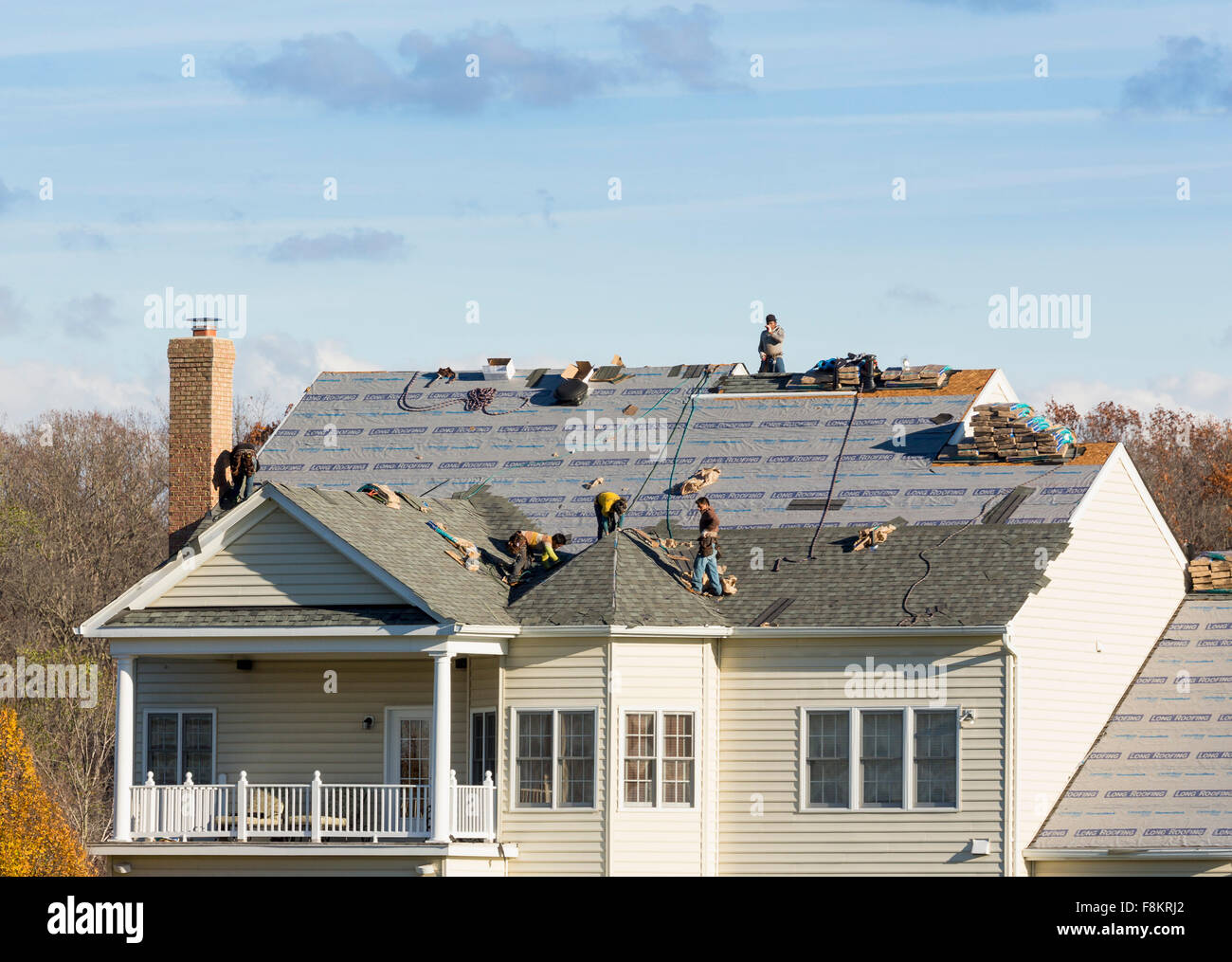 Des ouvriers sur toit d'une maison américaine de remplacer les bardeaux d'asphalte et dalles en France Banque D'Images