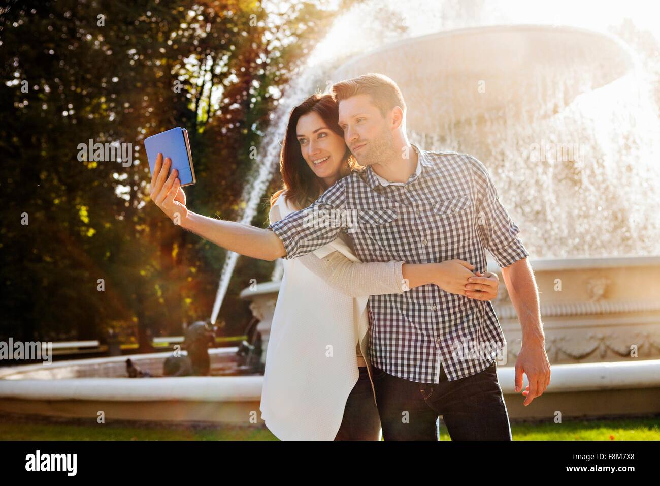 Couple sur selfies digital tablet in park Banque D'Images
