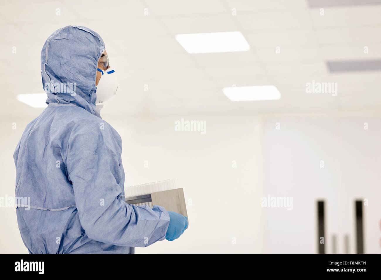 Scientist carrying tray of test tubes in laboratory Banque D'Images