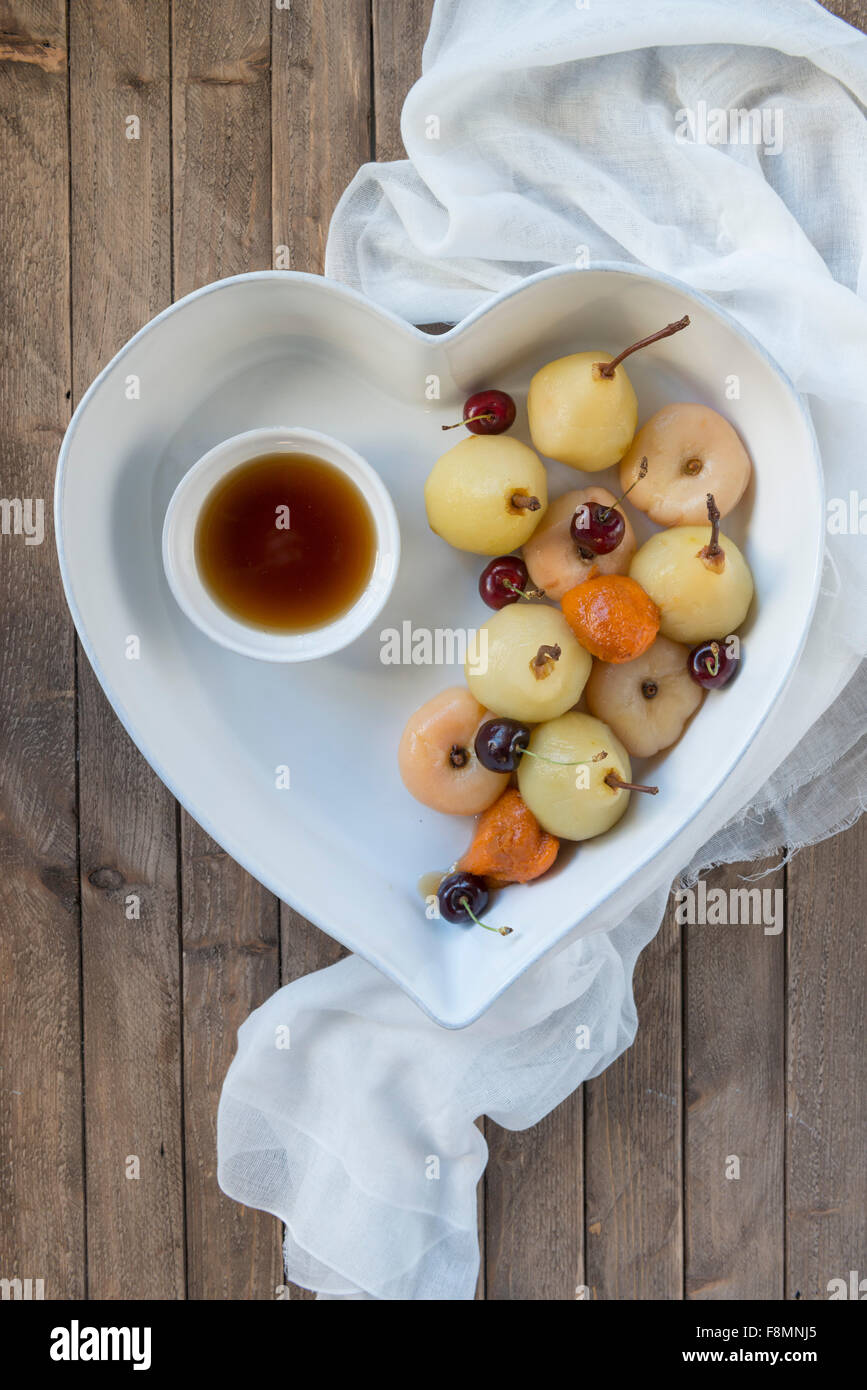Fruits pochés dans un plat en forme de coeur. Banque D'Images