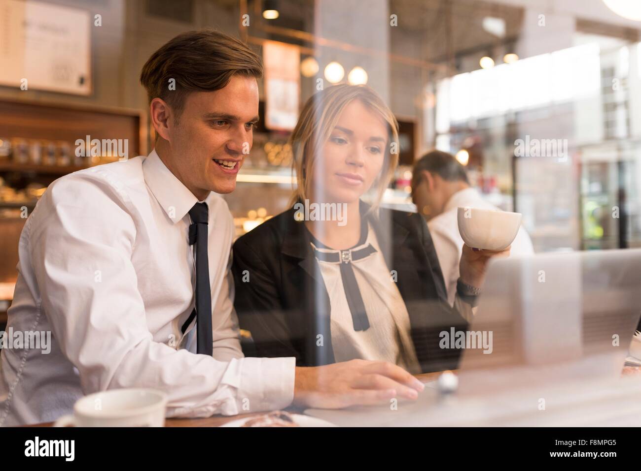 Businessman and businesswoman working on laptop in cafe Banque D'Images