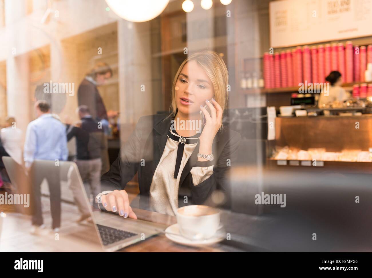 Businesswoman working on laptop in cafe Banque D'Images