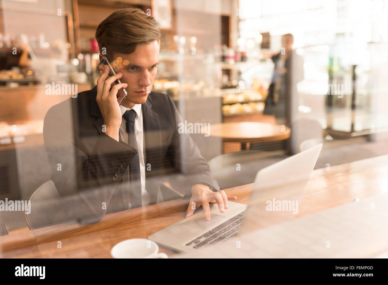 Businessman working on laptop in cafe Banque D'Images
