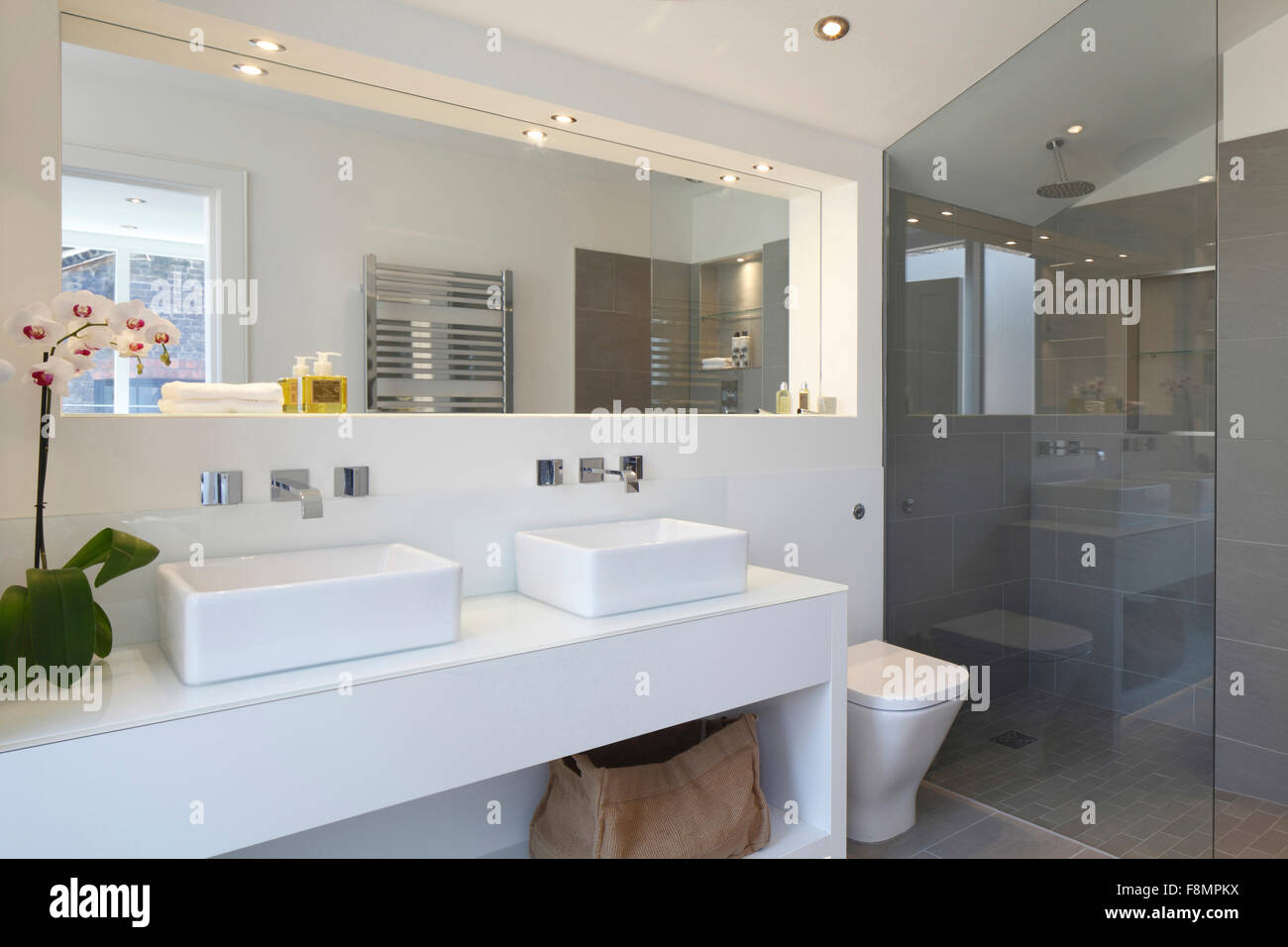 Salle de bains avec deux lavabos blancs sur fond blanc lavabo, sol carrelé  gris et cabine de douche. Lumières sur Photo Stock - Alamy