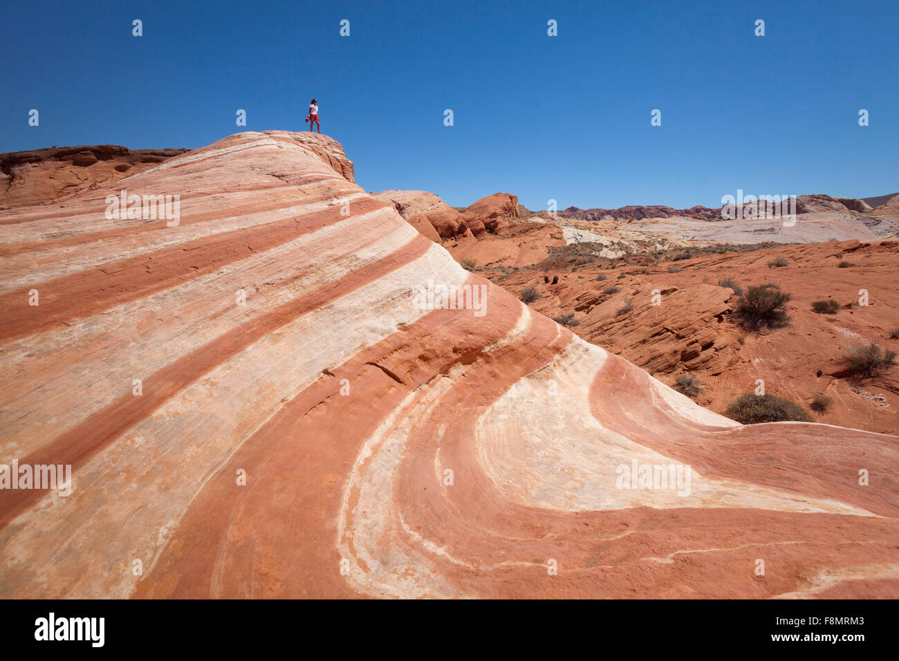 Fille, gisant dans le désert vague de la vallée de Feu, Nevada Banque D'Images