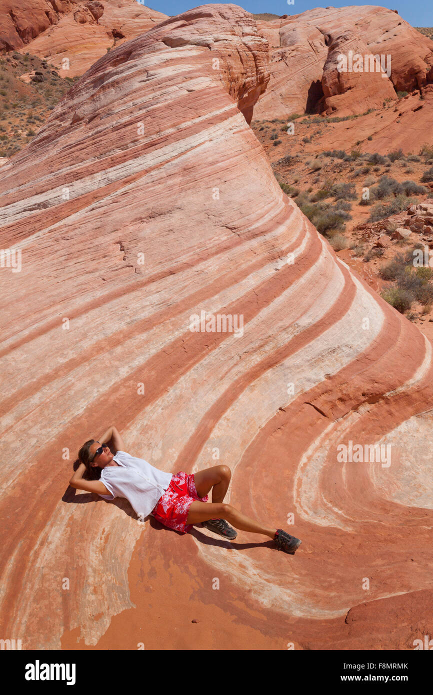 Fille, gisant dans le désert vague de la Vallée de Feu, Nevada Banque D'Images
