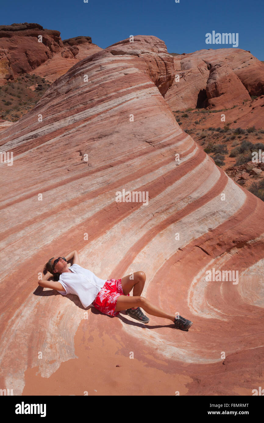Fille, gisant dans le désert vague de la Vallée de Feu, Nevada Banque D'Images