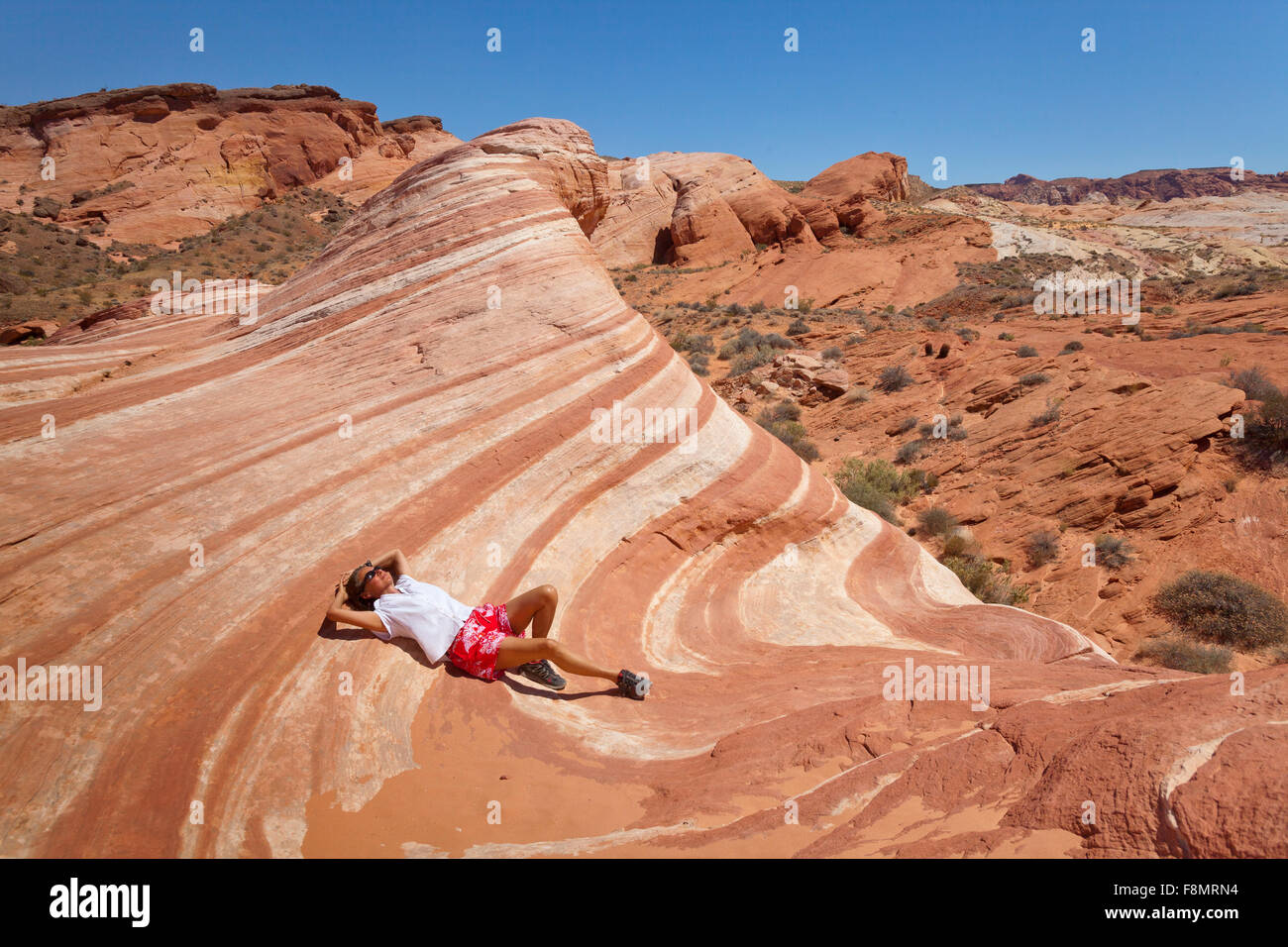 Fille, gisant dans le désert vague de la vallée de Feu, Nevada Banque D'Images