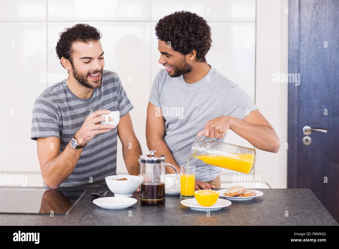 Heureux couple gay, le petit-déjeuner et parler Banque D'Images