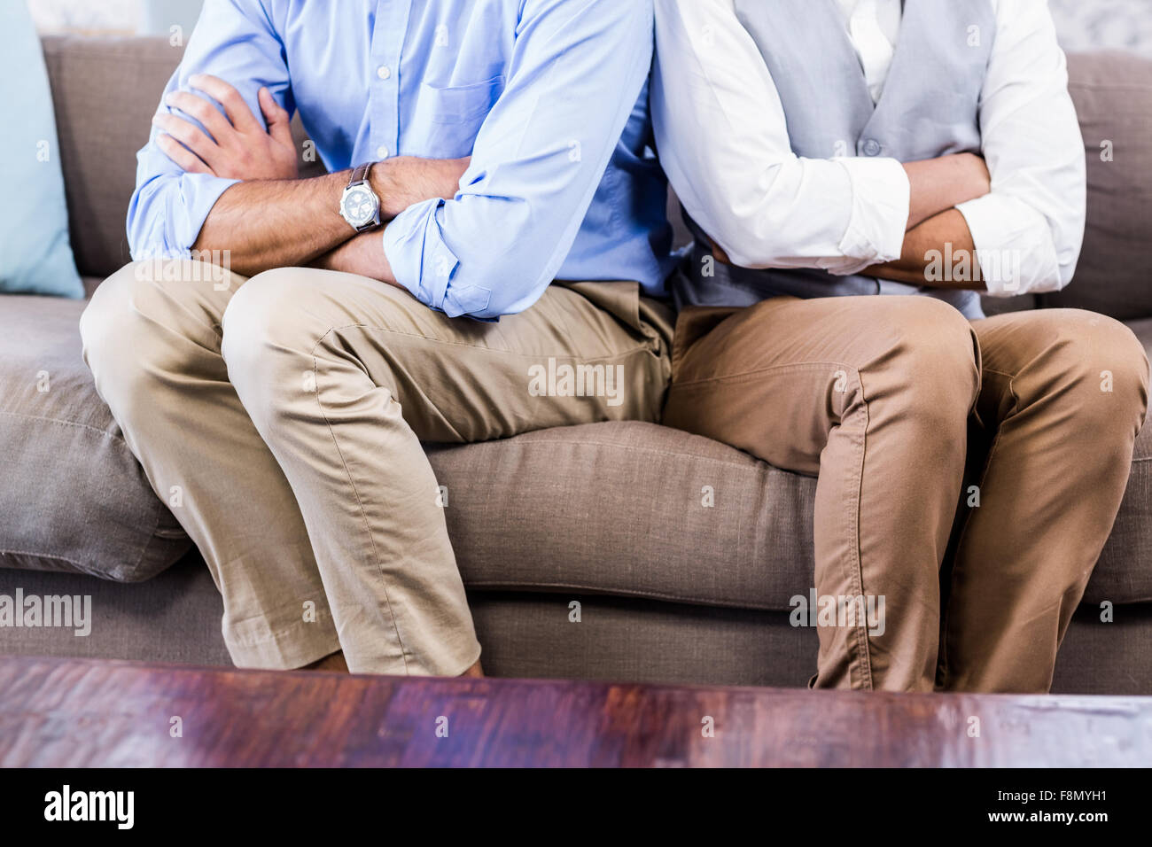 Gay couple sitting back-to-back après disputes Banque D'Images