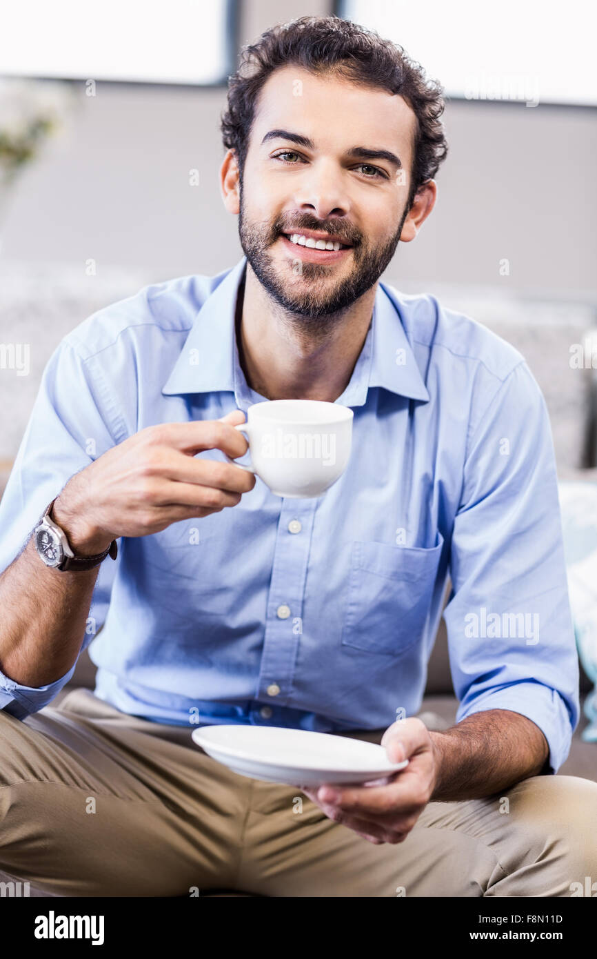 Smiling man holding cup looking at camera Banque D'Images