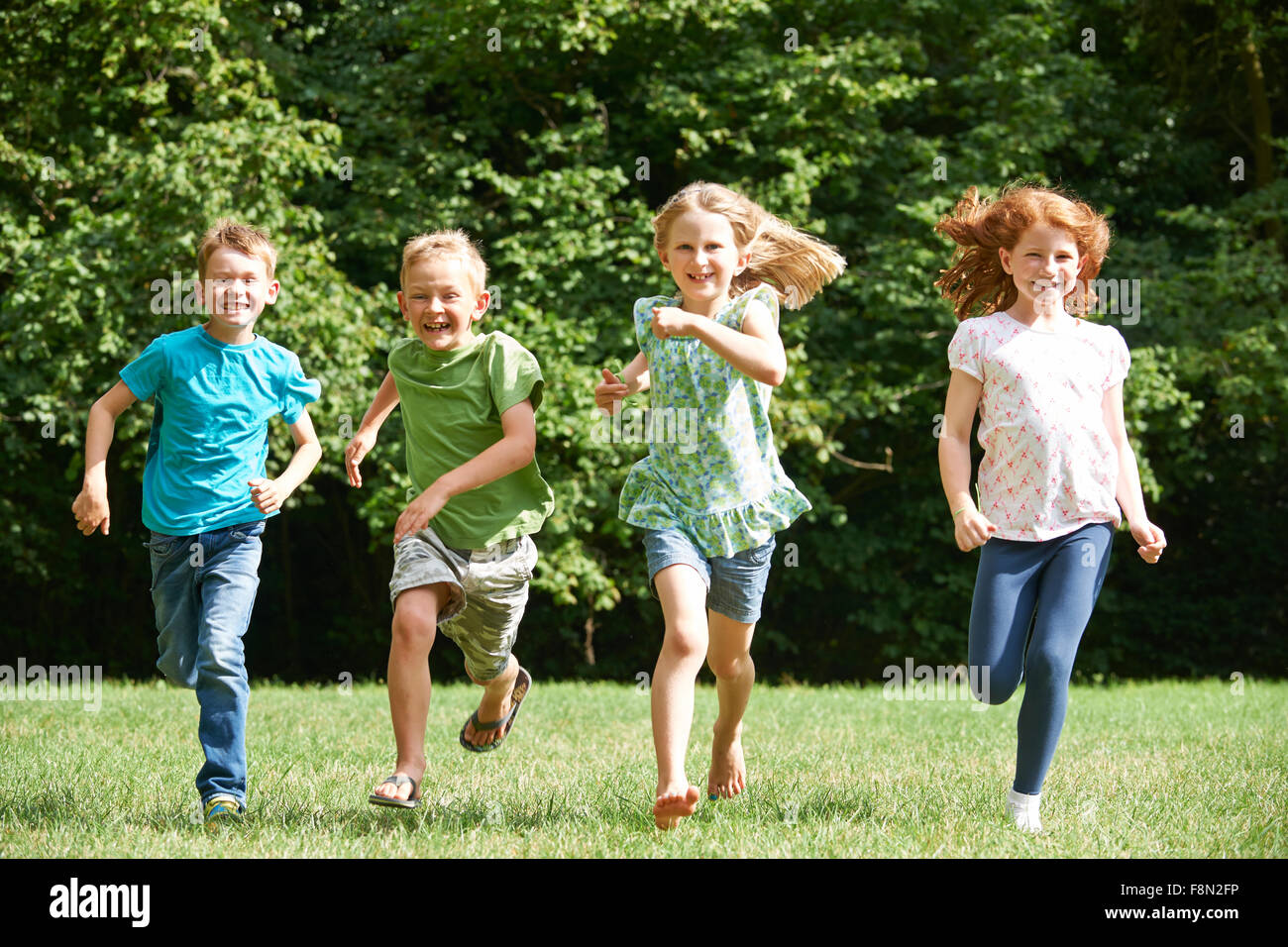 Groupe d'enfants qui courent vers la caméra en jeu pour enfants Banque D'Images