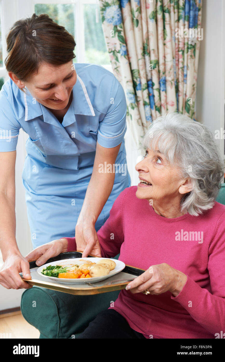 Carer servant le déjeuner à Senior Woman Banque D'Images