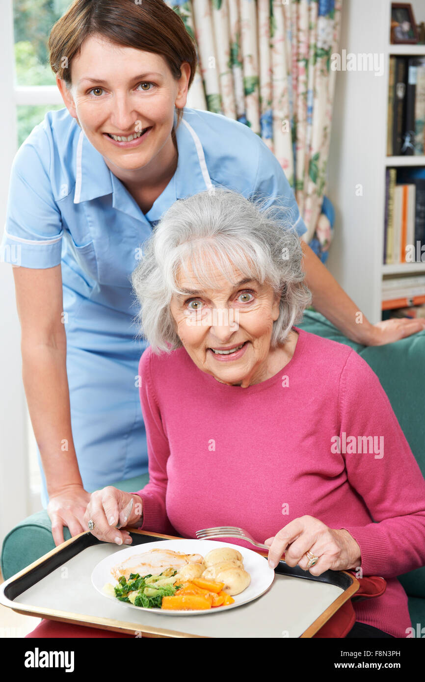 Carer servant le déjeuner à Senior Woman Banque D'Images
