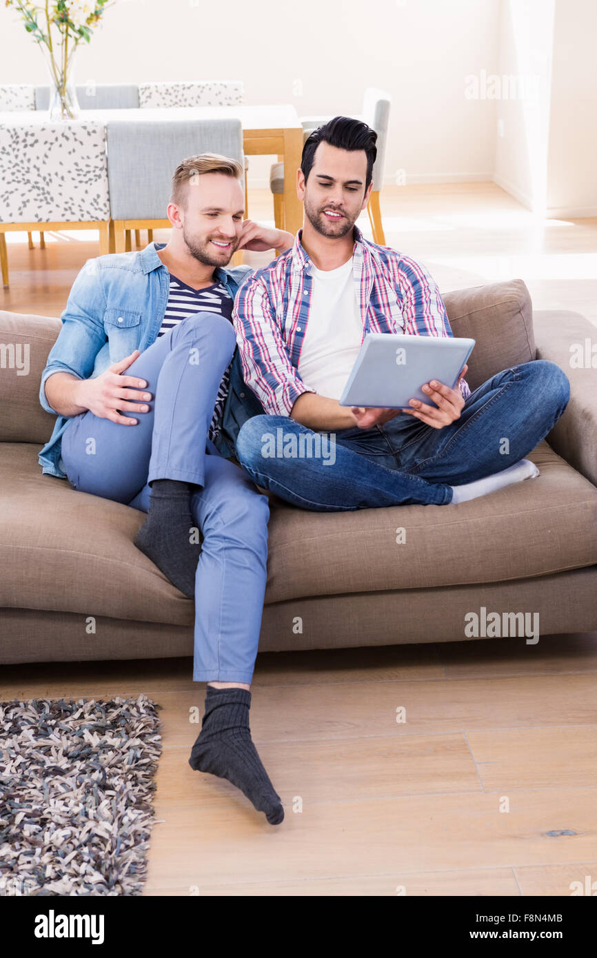 Couple Gay, se détendre sur la table à l'aide de tablet Banque D'Images
